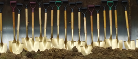 Golden ceremonial shovels in freshly turned earth